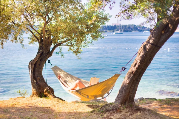 Dame liest Buch in Hängematte. — Stockfoto