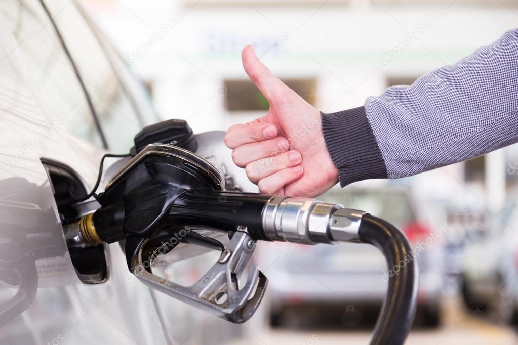 Petrol being pumped into a motor vehicle car.