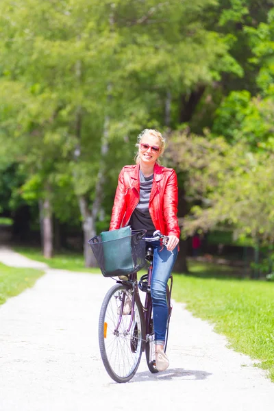 Bisiklet süren genç bir kadın. — Stok fotoğraf
