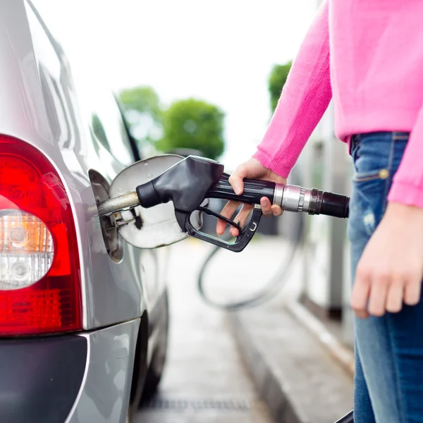 Frau pumpt Benzin in Auto an Tankstelle. — Stockfoto