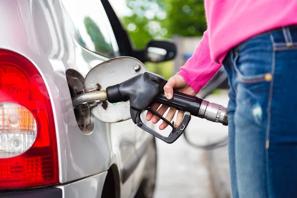 Frau pumpt Benzin in Auto an Tankstelle. — Stockfoto