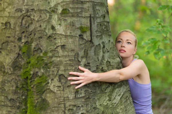 Jeune femme étreignant un arbre . — Photo