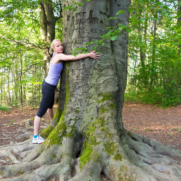 Junge Frau umarmt einen Baum. — Stockfoto