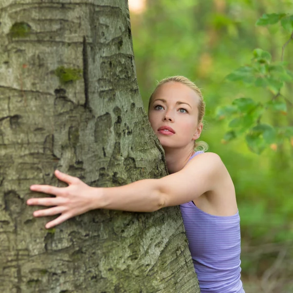 Jeune femme étreignant un arbre . — Photo