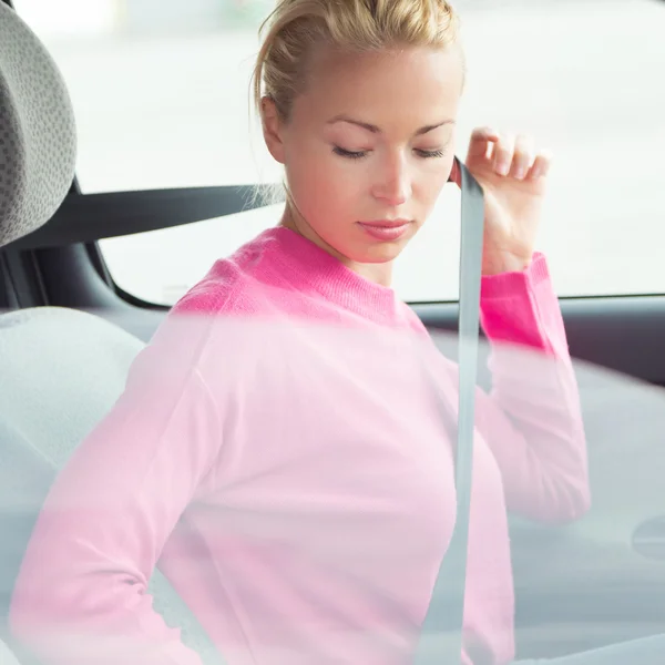 Beautiful woman fastening seat belt. — Stock Photo, Image