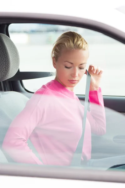 Beautiful woman fastening seat belt. — Stock Photo, Image