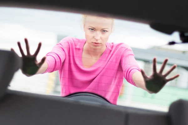 Frau schubst Auto. — Stockfoto