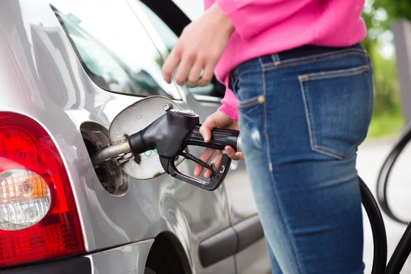 Frau pumpt Benzin in Auto an Tankstelle. — Stockfoto