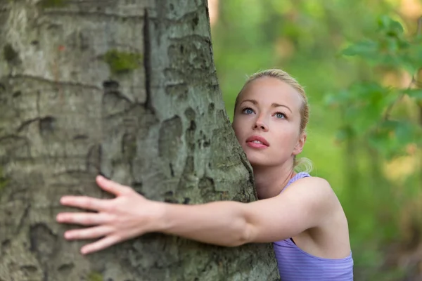 Jeune femme étreignant un arbre . — Photo