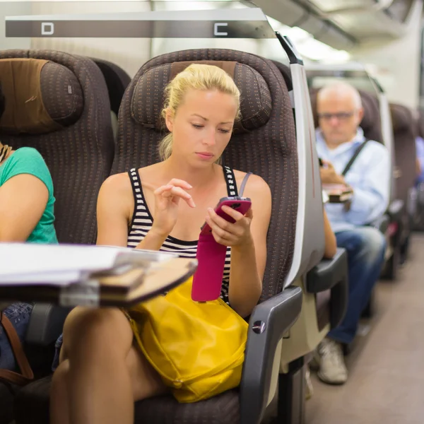 Леди путешествует на поезде с помощью смартфона . — стоковое фото