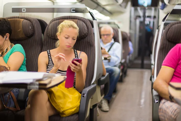 Frau mit Smartphone im Zug unterwegs. — Stockfoto
