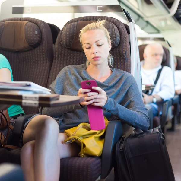 Lady traveling by train using smartphone. — Stock Photo, Image