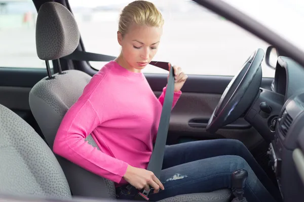 Beautiful woman fastening seat belt. — Stock Photo, Image