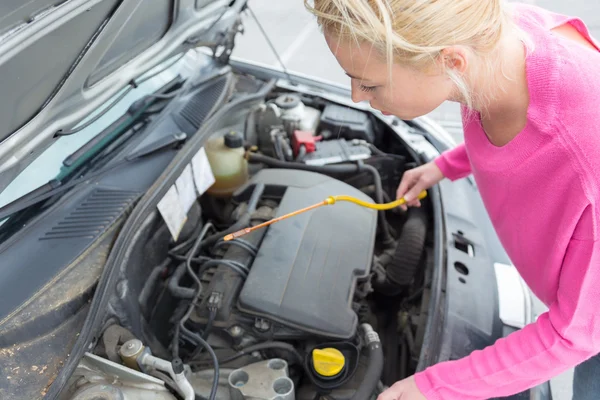 Mulher inspecionando motor de carro quebrado . — Fotografia de Stock