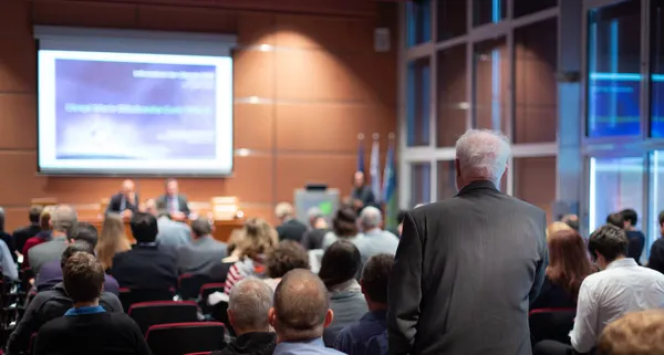 Jag har en fråga. Grupp affärsmän som sitter i konferenssalen. Affärsman som lyfter armen. Konferens och presentation. Företag och entreprenörskap — Stockfoto