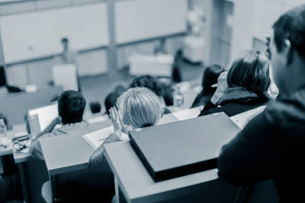 Ponente presentando en la sala de conferencias de la universidad. Participantes escuchando conferencias y tomando notas. — Foto de Stock