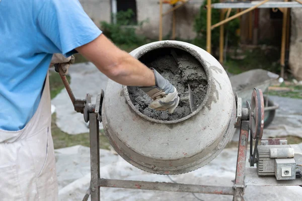 Pekerja buruh yang beroperasi semen beton mixer di lokasi konstruksi. — Stok Foto