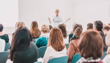 İş toplantısında kadın konuşmacı bir konuşma yapıyor. Konferans salonunda dinleyiciler. İş ve Girişimcilik Sempozyumu.