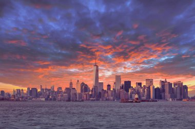 New York City Manhattan şehir merkezi alacakaranlıkta gökdelenler Hudson Nehri panoramasını aydınlatıyor. Dramatik gün batımı gökyüzü.