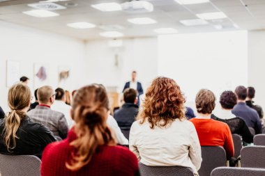 Sözcü iş toplantısında bir konuşma yapacak. Konferans salonunda dinleyiciler. İş ve Girişimcilik Sempozyumu.