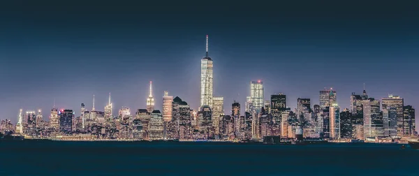 New York City Manhattan downtown skyline at dusk with skyscrapers illuminated over Hudson River panorama. — Stock Photo, Image