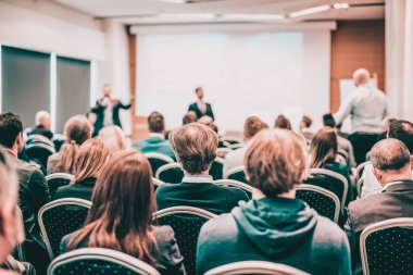 Benim bir sorum var. Bir grup iş adamı konferans salonunda oturuyor. İş adamı kolunu kaldırıyor. Konferans ve Sunum. İş ve Girişimcilik