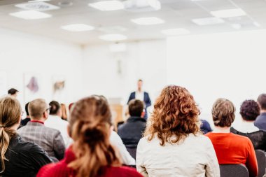 Sözcü iş toplantısında bir konuşma yapacak. Konferans salonunda dinleyiciler. İş ve Girişimcilik Sempozyumu.