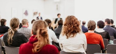 İş toplantısında kadın konuşmacı bir konuşma yapıyor. Konferans salonunda dinleyiciler. İş ve Girişimcilik Sempozyumu.