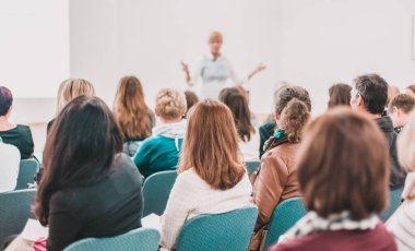 İş toplantısında kadın konuşmacı bir konuşma yapıyor. Konferans salonunda dinleyiciler. İş ve Girişimcilik Sempozyumu.