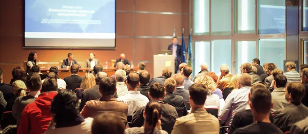 Mluvčí přednáší v konferenčním sále na obchodní schůzce. Zadní pohled na nepoznatelné diváky v konferenčním sále. — Stock fotografie