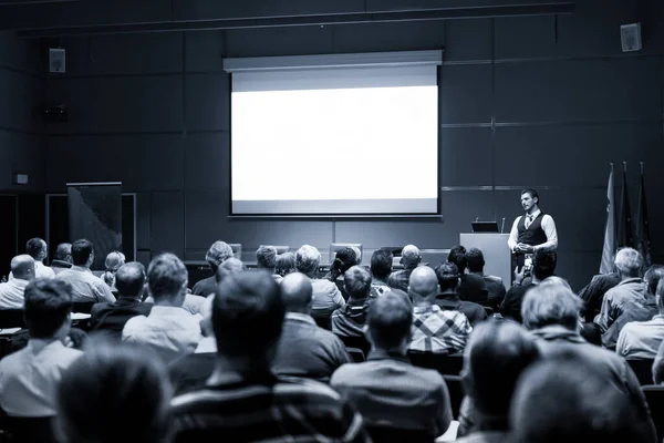 Ομιλητής δίνει ομιλία σε επαγγελματική συνάντηση. Το κοινό στην αίθουσα συνεδριάσεων. Επιχείρηση και επιχειρηματικότητα έννοια. Μαύρο και άσπρο μπλε τονισμένη εικόνα — Φωτογραφία Αρχείου