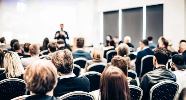 Talmannen håller ett föredrag i konferenssalen på affärsevenemanget. Bakifrån av oigenkännliga människor i publiken i konferenslokalen. Affärs- och entreprenörskapskoncept. — Stockfoto