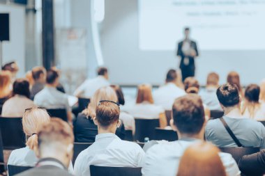Sözcü, iş konferansında konferans salonunda konuşma yapacak. Konferans salonundaki tanınmayan insanların arka görüntüsü. İş ve girişimcilik kavramı.
