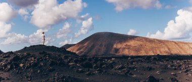 Kadın turist, İspanya 'nın Lanzarote kentindeki Timanfaya ulusal parkında volkanik manzaranın tadını çıkarıyor. Özgürlük ve seyahat macera konsepti