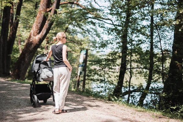 Visão Traseira Mãe Vestida Casualmente Andando Com Carrinho Bebê Parque — Fotografia de Stock