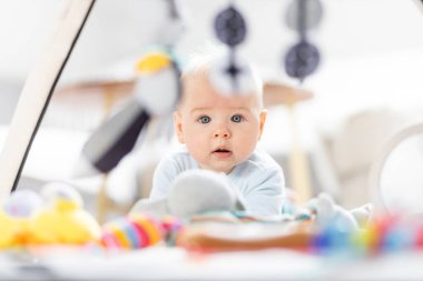 Bebek oyuncaklarıyla oynayan sevimli bir çocuk. Bebek aktivitesi ve çocuk gelişimi için oyun merkezi. Evde oynayan bebek..