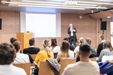 Sözcü, iş konferansında konferans salonunda konuşma yapacak. Konferans salonundaki tanınmayan insanların arka görüntüsü. İş ve girişimcilik kavramı
