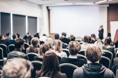 Sözcü, iş konferansında konferans salonunda konuşma yapacak. Konferans salonundaki tanınmayan insanların arka görüntüsü. İş ve girişimcilik kavramı