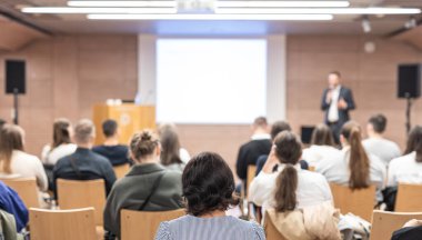 Sözcü, iş konferansında konferans salonunda konuşma yapacak. Konferans salonundaki tanınmayan insanların arka görüntüsü. İş ve girişimcilik kavramı