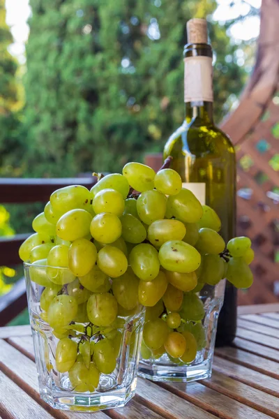 Glasses full of grapes and a bottle of wine — Stock Photo, Image