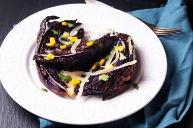 Sağlıklı gıda kavramı vejetaryen kavrulmuş kırmızı lahana bifteği beyaz seramik tabakta siyah tahta üzerinde fotokopi alanı ile birlikte.