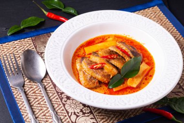 Tayland yemeği konsepti Tayland hindistan cevizi sütü kırmızı köri ördeği beyaz seramik çorba tabağında Tayland usulü otlar ve kopyalama alanı