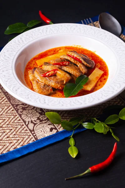 Tayland yemeği konsepti Tayland hindistan cevizi sütü kırmızı köri ördeği beyaz seramik çorba tabağında Tayland usulü otlar ve kopyalama alanı