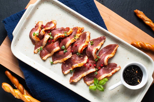 Food concept Spicy Smoked duck breast in ceramic plate on wooden board with copy space