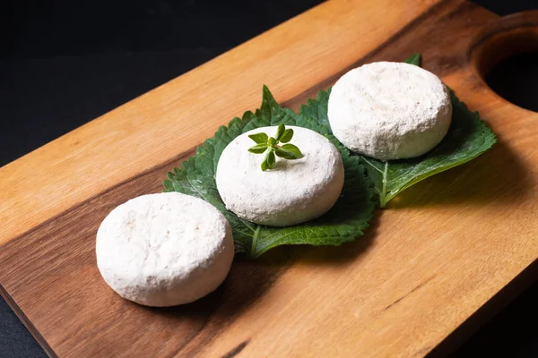 Food concept French organic goat cheese Picodon form southern France on wooden board with copy space