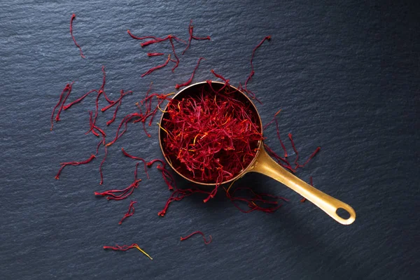 Food ingredient spice concept Saffron crocus spice in copper cup on black background with copy space