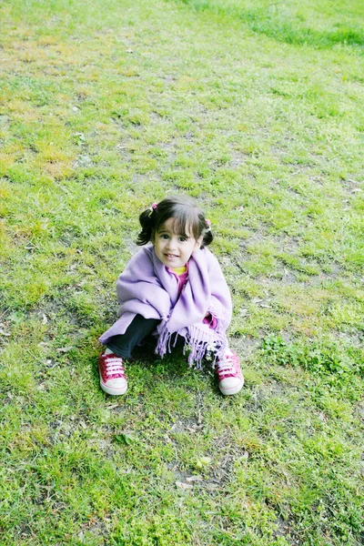 Little girl sitting in the grass - Family life — Stock Photo, Image