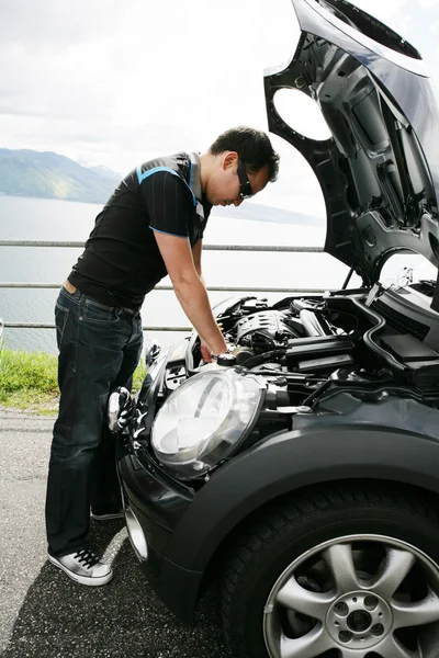 Een jonge man zijn auto tot vaststelling van de heuvels — Stockfoto