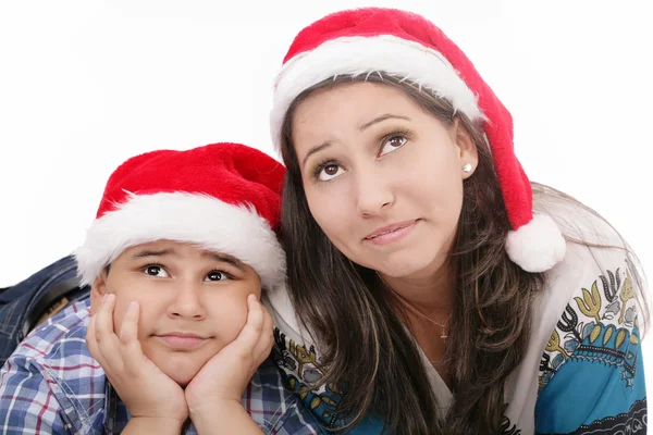 Μητέρα και γιος σε καπέλα santa χαμογελώντας και κοιτώντας ψηλά Royalty Free Εικόνες Αρχείου