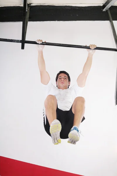 Fit homem realizando pull ups em um bar — Fotografia de Stock